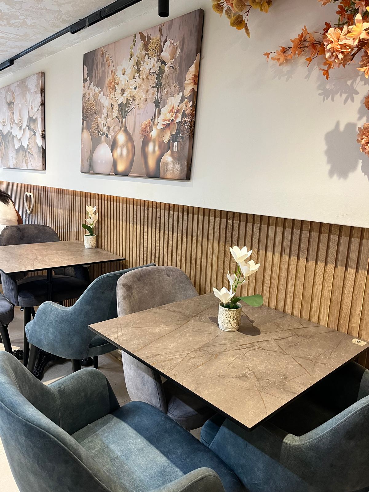 Table en marbre, fauteuils en velours et mur de tasseaux